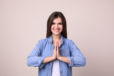 Photo of Young woman meditating on light background. Stress relief exercise