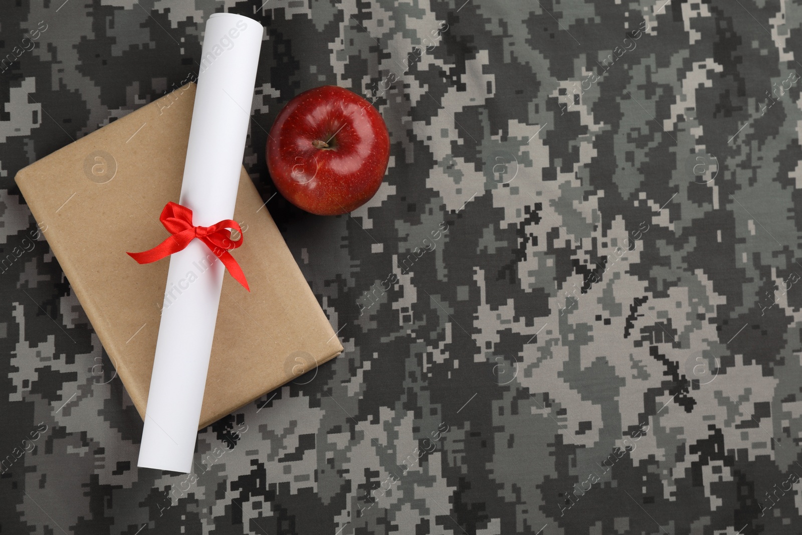 Photo of Book, apple and diploma on camouflage background, flat lay with space for text. Military education concept