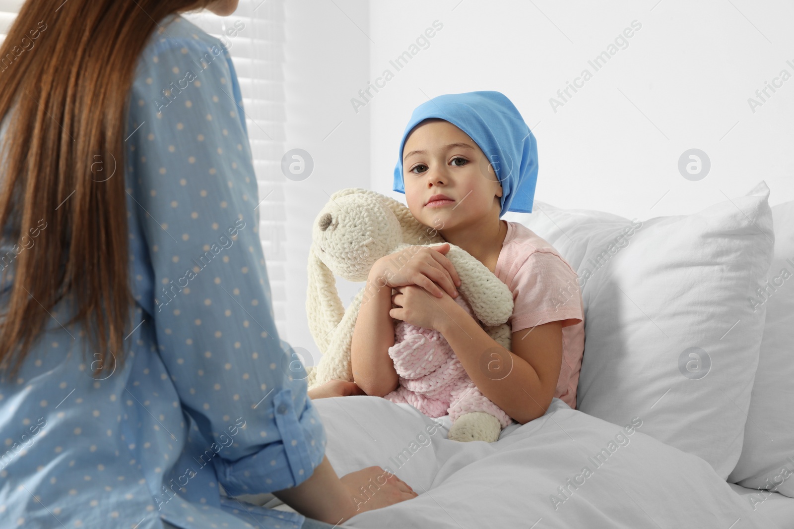 Photo of Childhood cancer. Mother and daughter with toy bunny in hospital