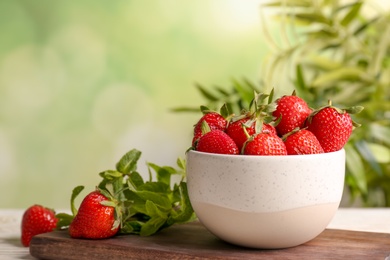 Bowl with ripe red strawberries on table