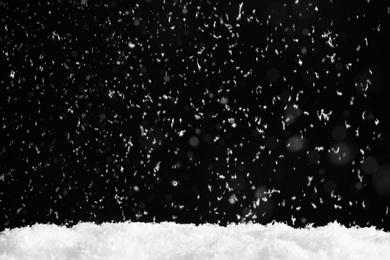 Photo of Snow flakes falling on black background. Winter weather