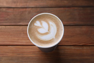 Coffee to go. Paper cup with tasty drink on wooden table, above view