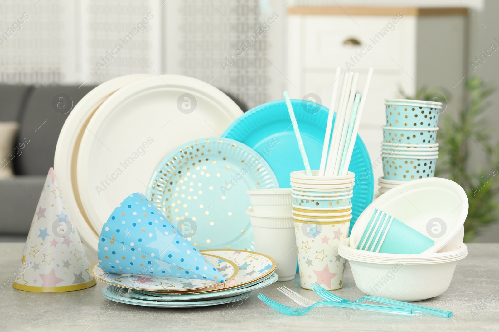 Photo of Disposable tableware on light grey table indoors