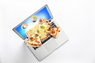 Image of Modern laptop with open page of online food delivery service on white background, top view