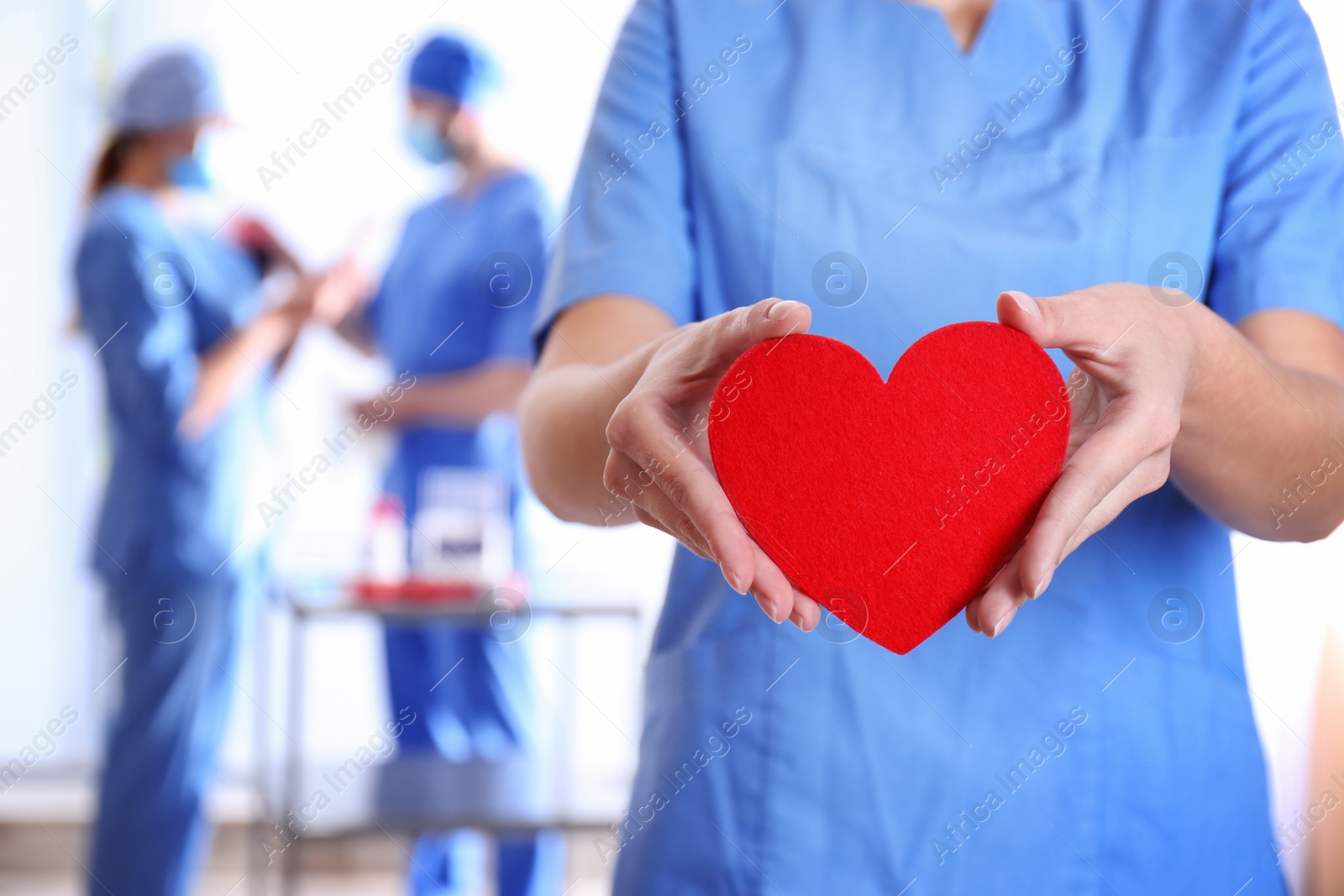 Photo of Doctor holding red heart at hospital, closeup. Donation day
