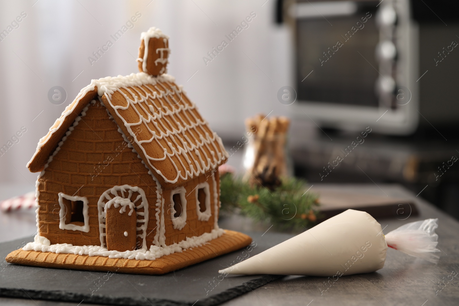 Photo of Beautiful gingerbread house decorated with icing on table