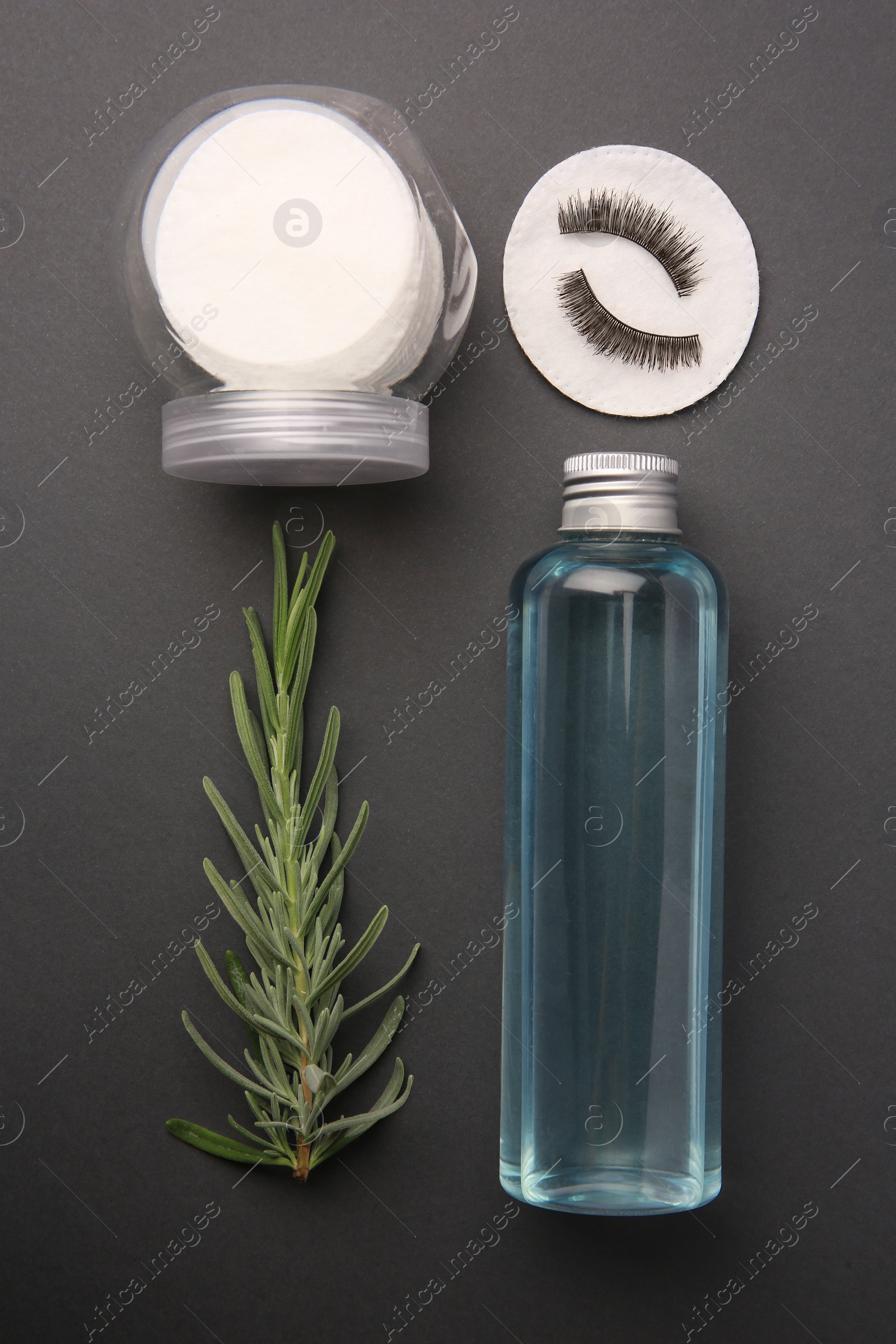 Photo of Flat lay composition with makeup remover and false eyelashes on dark grey background