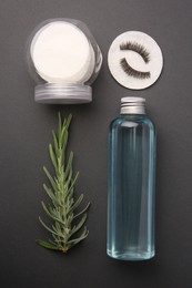 Flat lay composition with makeup remover and false eyelashes on dark grey background