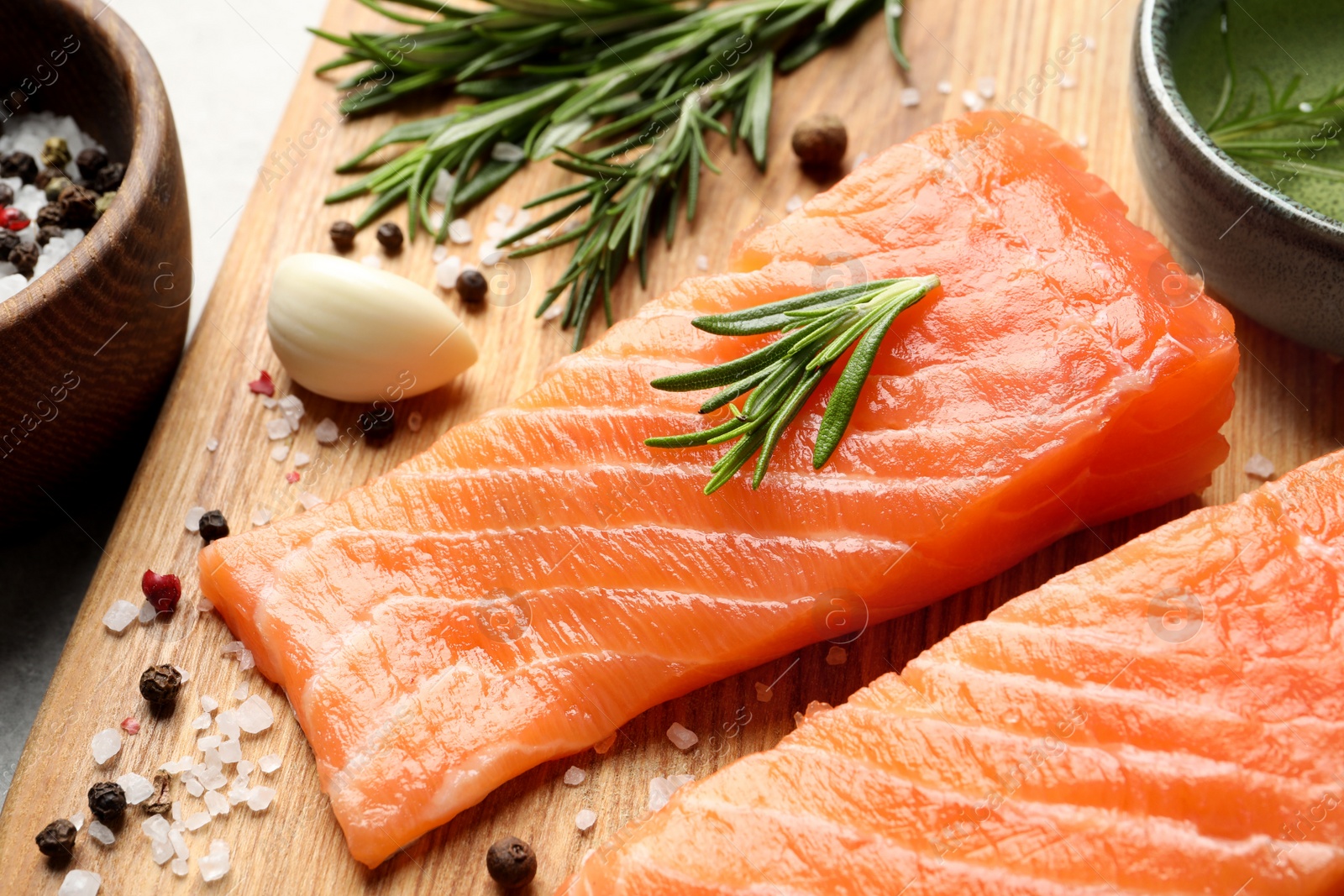 Photo of Fresh raw salmon and ingredients for marinade on wooden board, closeup