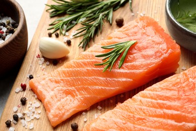 Fresh raw salmon and ingredients for marinade on wooden board, closeup