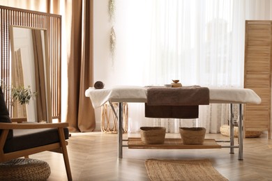 Photo of Stylish room interior with massage table in spa salon