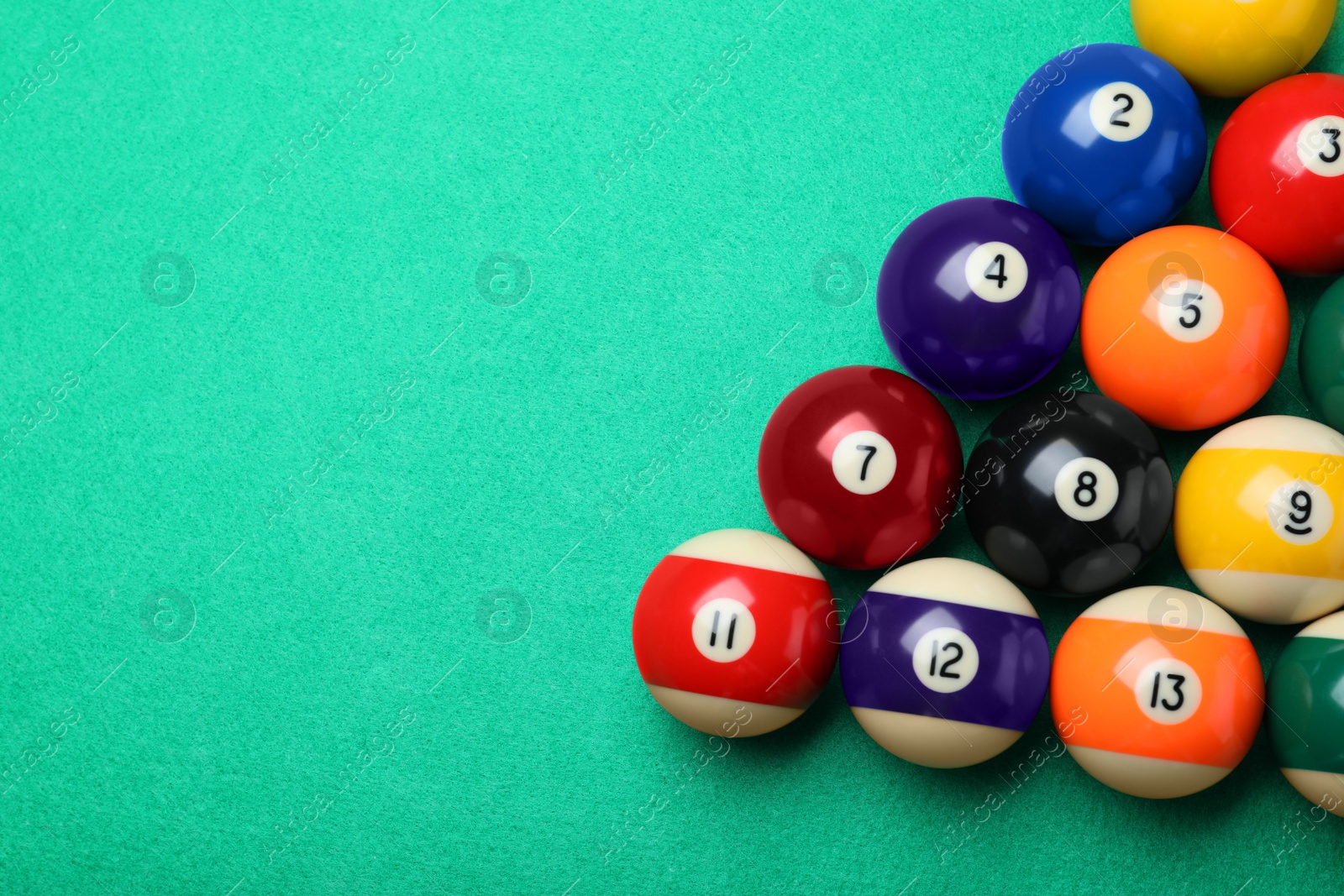 Photo of Set of billiard balls on green table, flat lay. Space for text