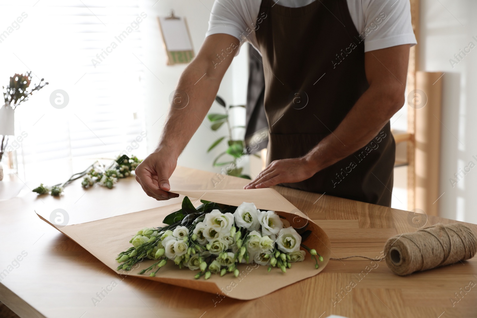 Photo of Florist making beautiful bouquet in workshop, closeup