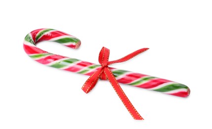 Photo of Sweet Christmas candy cane with red bow on white background