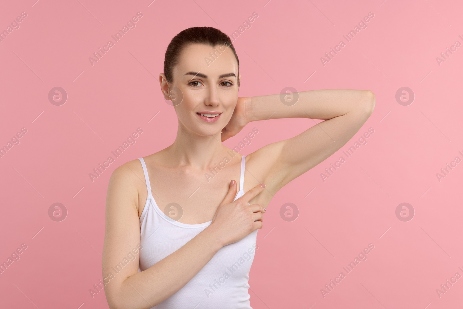 Photo of Beautiful woman showing armpit with smooth clean skin on pink background