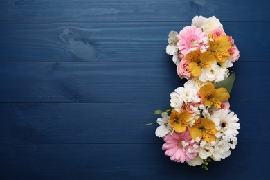 Photo of Number 8 made of beautiful flowers on blue wooden table, flat lay with space for text. International Women's day
