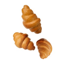 Crusty golden croissants falling on white background