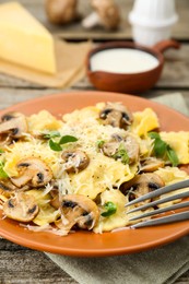 Photo of Delicious ravioli with mushrooms and cheese served on table, closeup