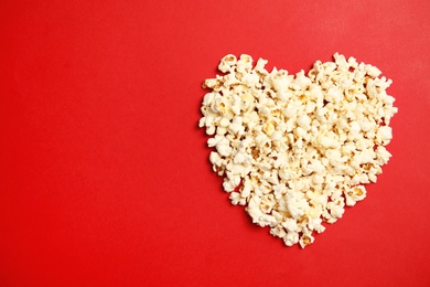 Photo of Tasty fresh popcorn on color background, top view