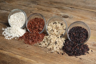 Photo of Different types of rice on wooden table