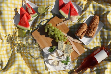 Photo of Delicious food and wine on picnic blanket, flat lay