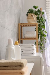 Photo of Soft towels, detergents and shelving unit indoors