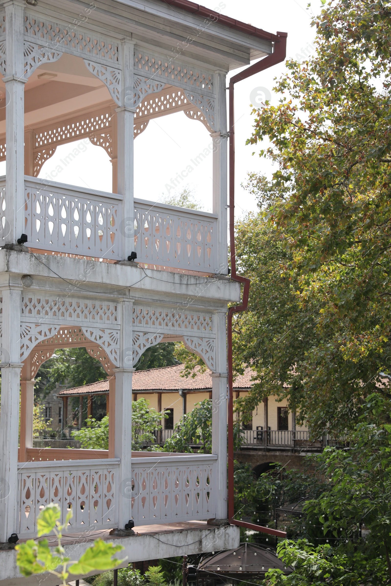 Photo of Kutaisi, Georgia - September 2, 2022: Beautiful white building near trees outdoors