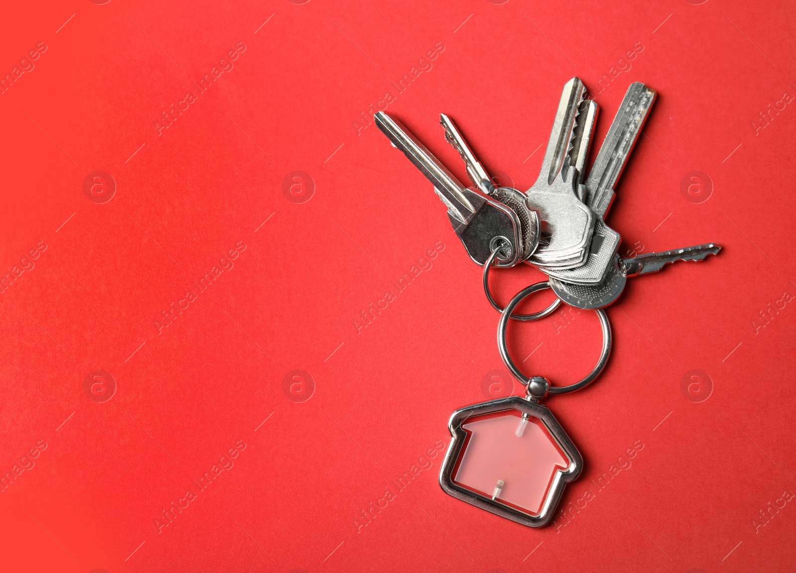 Photo of House keys with trinket on color background, top view. Space for text