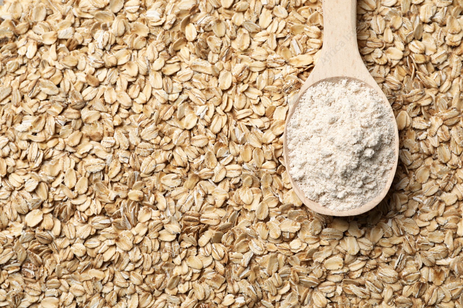 Photo of Spoon of gluten free flour on oatmeal, top view with space for text