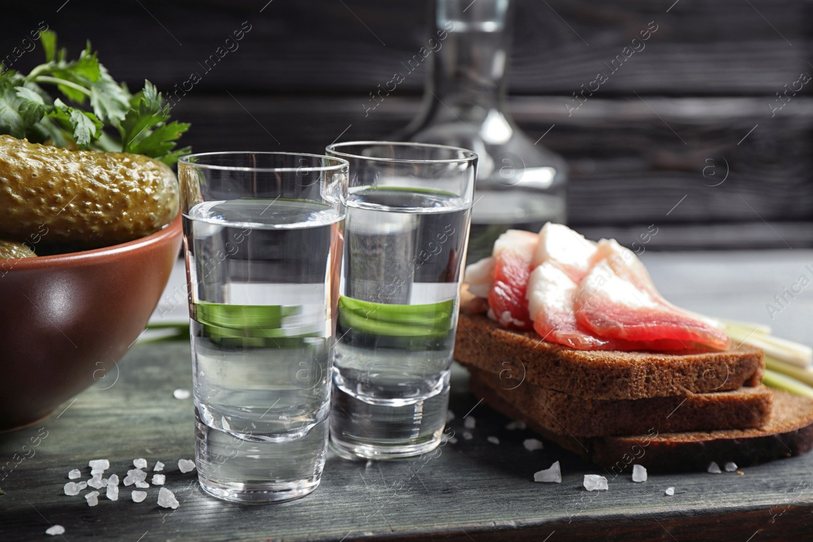 Photo of Cold Russian vodka with snacks on wooden table