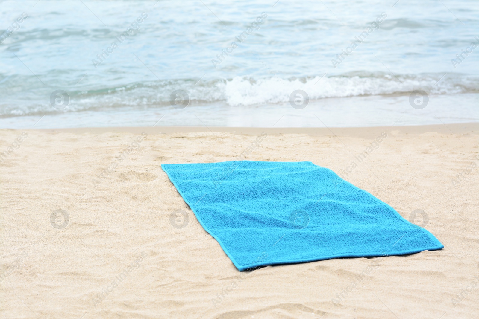 Photo of Blue towel on sandy beach near sea