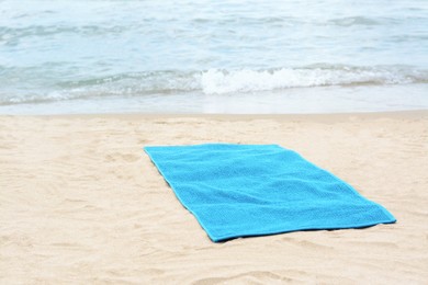 Photo of Blue towel on sandy beach near sea