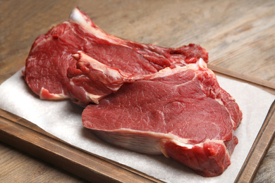 Fresh raw beef cut on wooden table, closeup