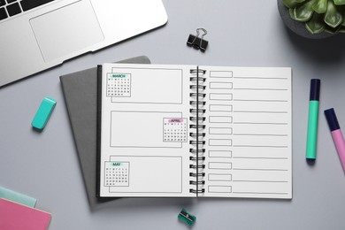 Image of Self organization with bullet journal. Notebook with calendar and empty planning lists near stationery on grey table, flat lay
