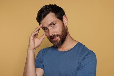 Photo of Portrait of handsome bearded man on yellow background
