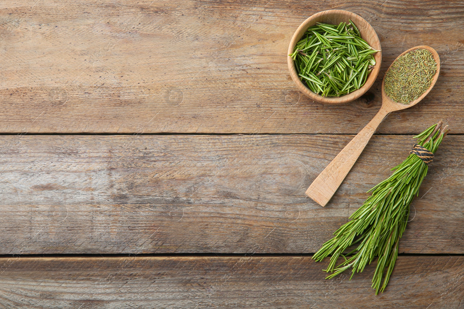 Photo of Dried rosemary and fresh twigs on wooden background, flat lay. Space for text