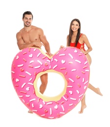 Photo of Young attractive couple in beachwear with inflatable ring on white background