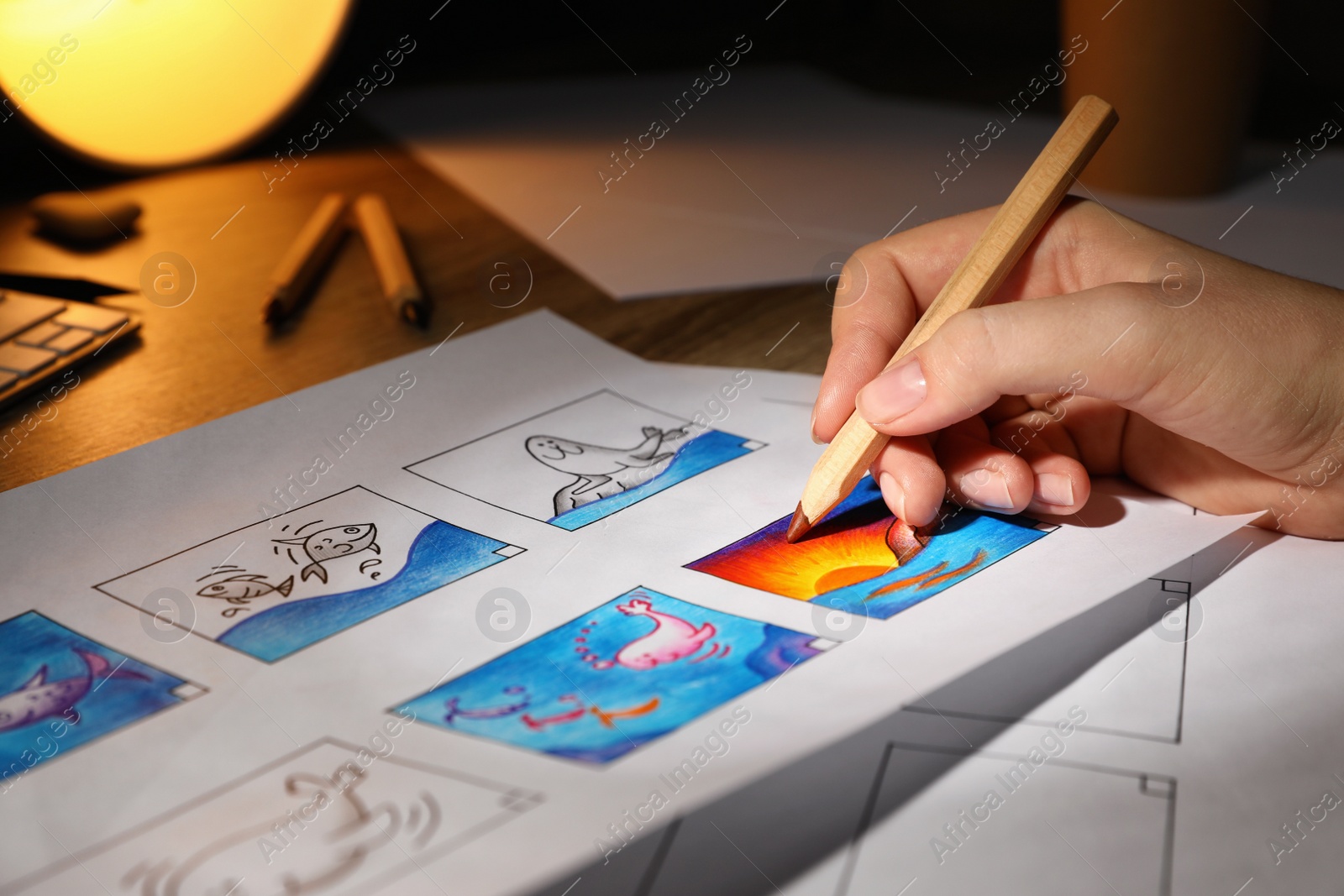 Photo of Woman drawing cartoon sketch in storyboard at workplace, closeup. Pre-production process