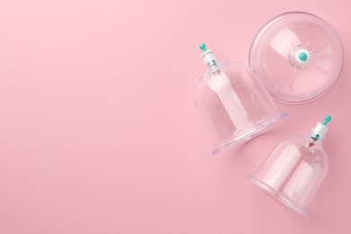 Photo of Plastic cups on pink background, flat lay with space for text. Cupping therapy