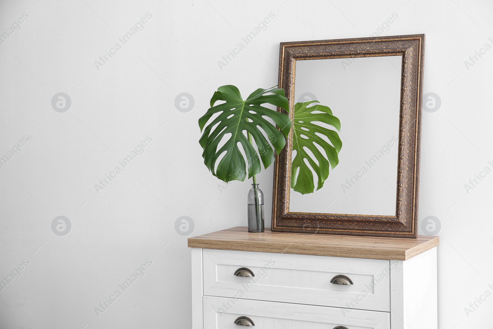 Photo of Elegant room interior with mirror on wooden cabinet