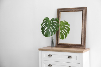 Elegant room interior with mirror on wooden cabinet