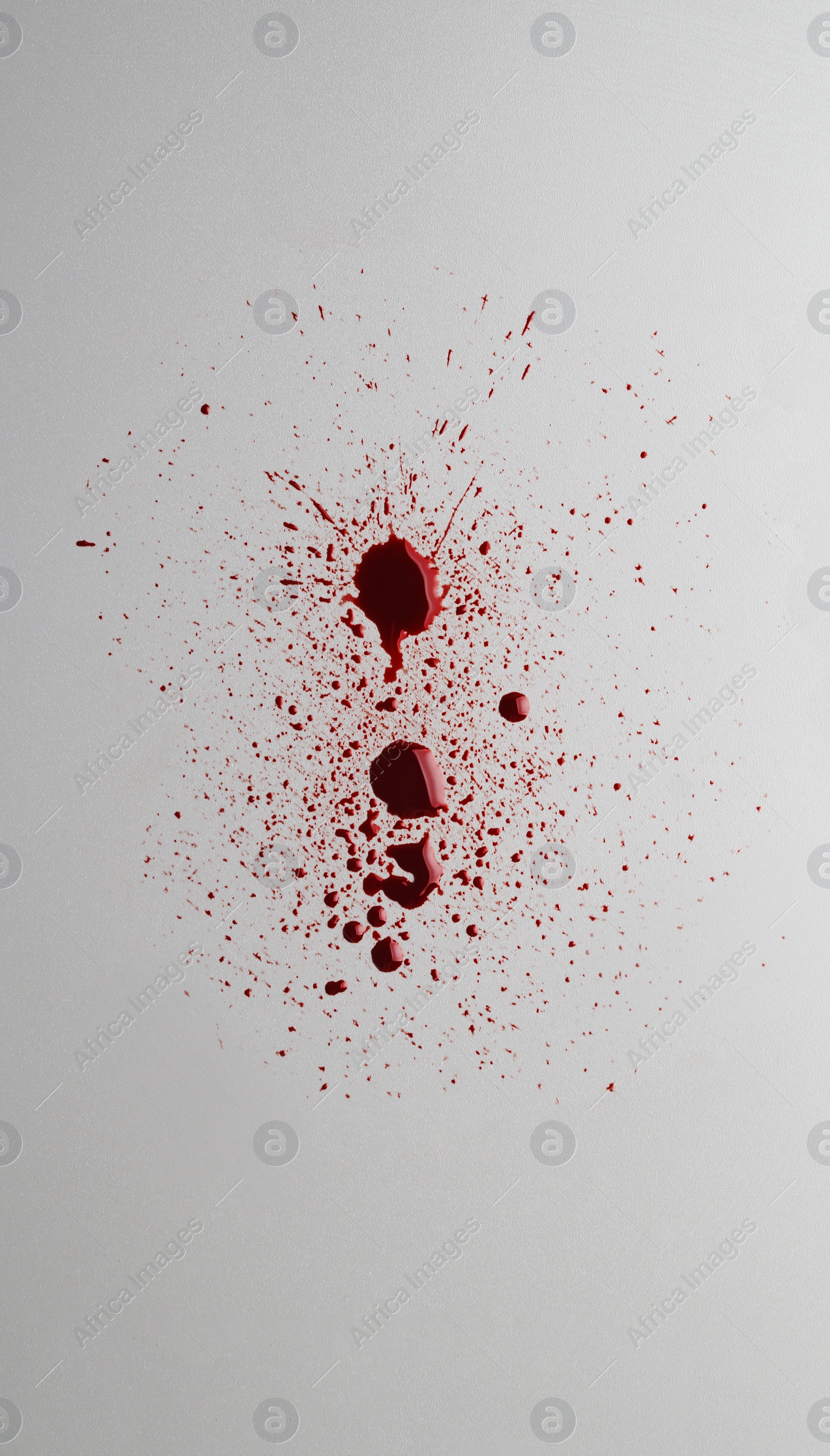 Photo of Stain and splashes of blood on light grey background, top view