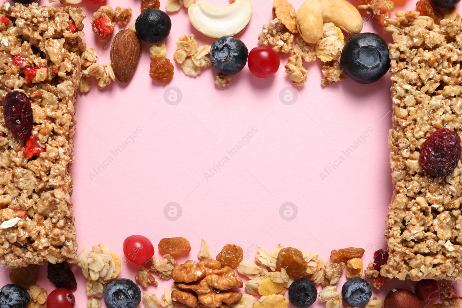 Photo of Frame made of tasty granola bars and ingredients on pink background, top view. Space for text