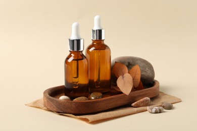 Photo of Composition with bottles of cosmetic serum on beige background