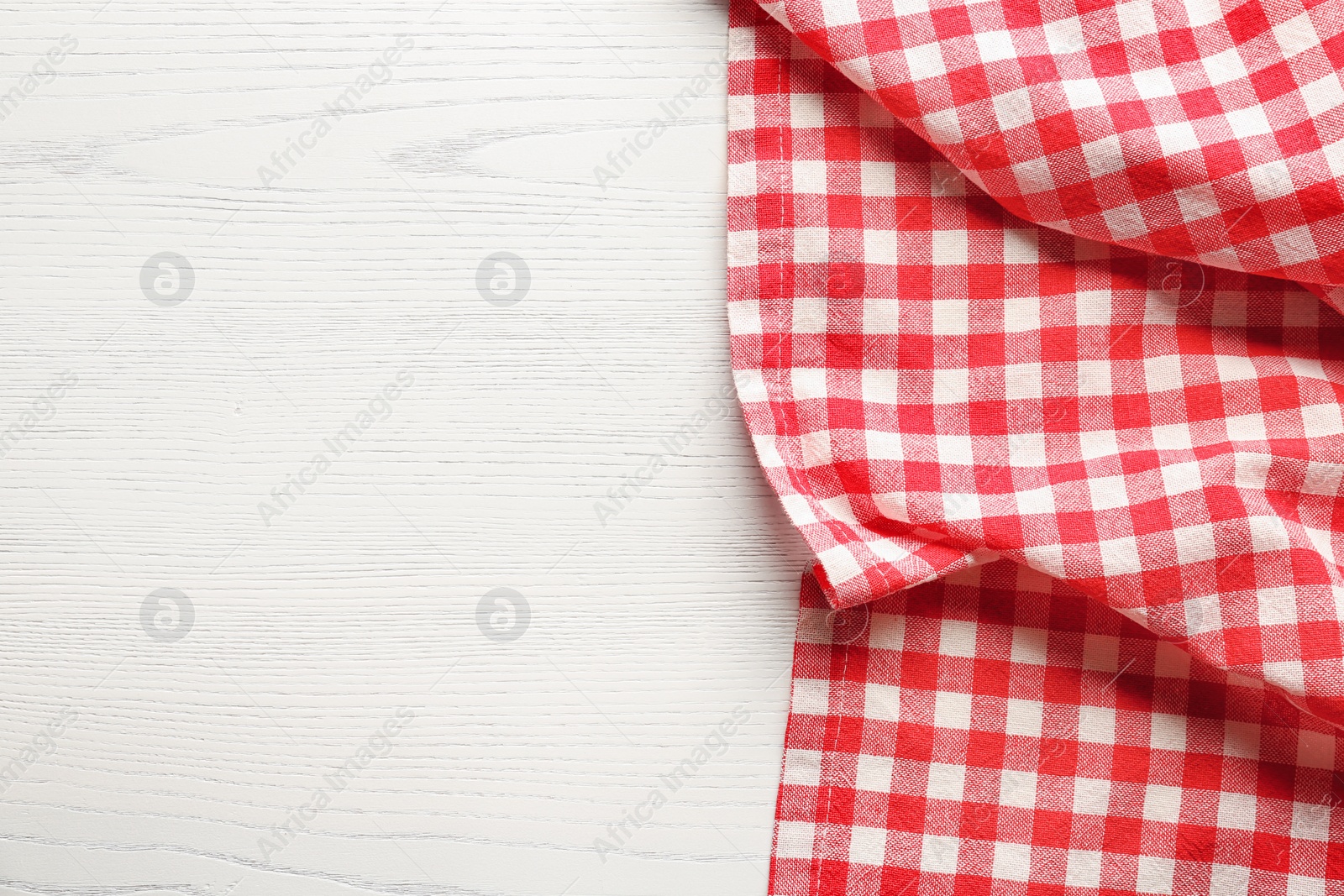 Photo of Checkered picnic tablecloth on wooden background, top view