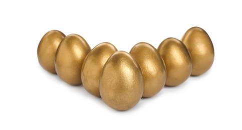 Photo of Many shiny golden eggs on white background