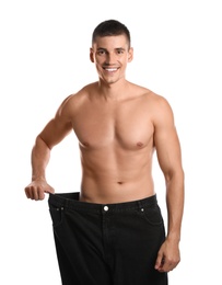 Photo of Young man with slim body in old big size jeans on white background