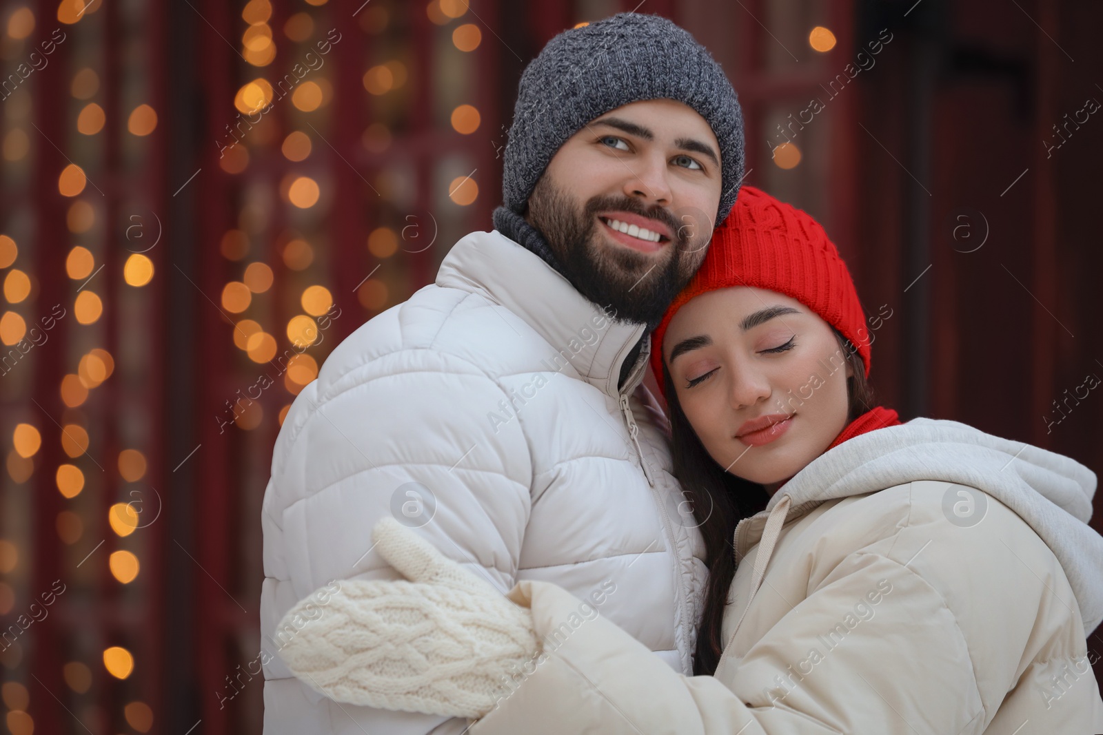 Photo of Portrait of lovely couple outdoors against blurred lights outdoors