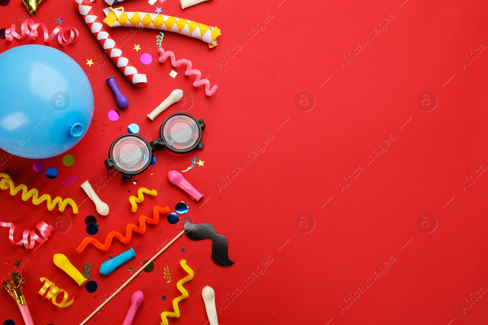 Photo of Flat lay composition with carnival items on red background. Space for text