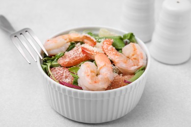 Delicious salad with pomelo, shrimps and tomatoes on white table